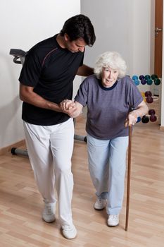 Therapist Helping Patient to walk with walking stick.