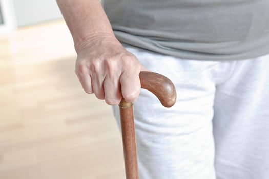 Close-up of elderly woman with walking stick.