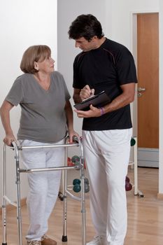 Patient with walker discusses his progress.