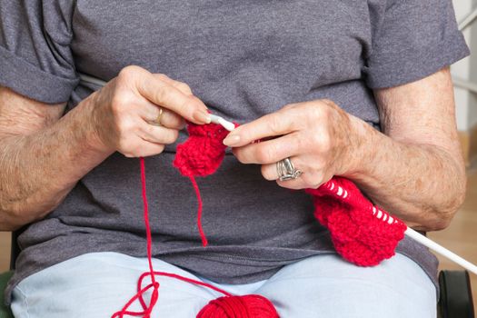 Mid section of senior woman knitting