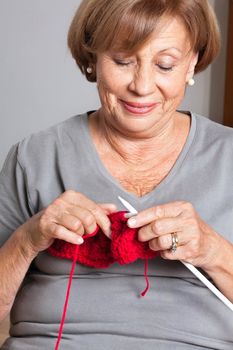 Happy senior woman knitting