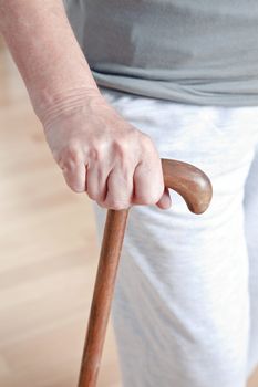 Close-up of elderly woman with walking stick.