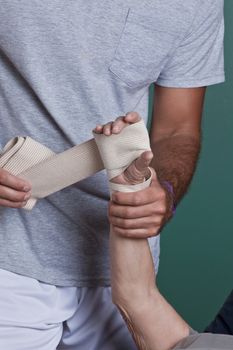 Therapist applying bandage on the hand.