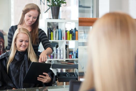 Female customer showing hair style on tablet computer