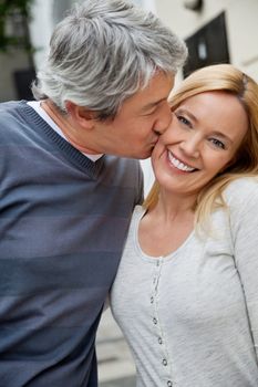 Middle aged man kissing happy woman