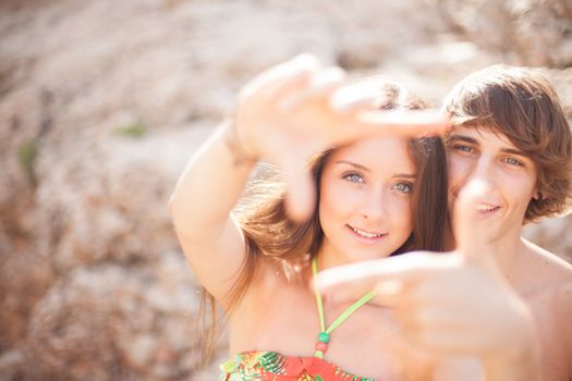 beautiful young couple having fun on the beach frame a picture