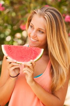 Portrait of a beautiful young woman eating watermelon