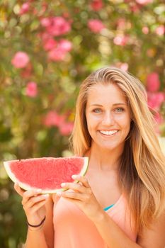 Portrait of a beautiful young woman eating watermelon