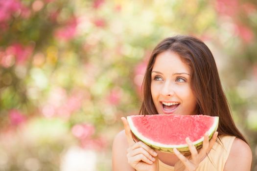 Portrait of a beautiful young woman eating watermelon