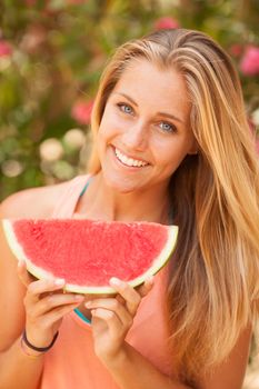 Portrait of a beautiful young woman eating watermelon