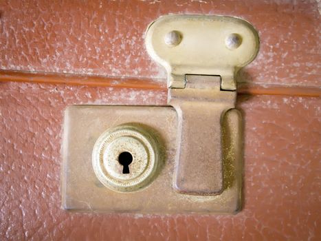 Detail of a rusty lock in an old brown suitcase