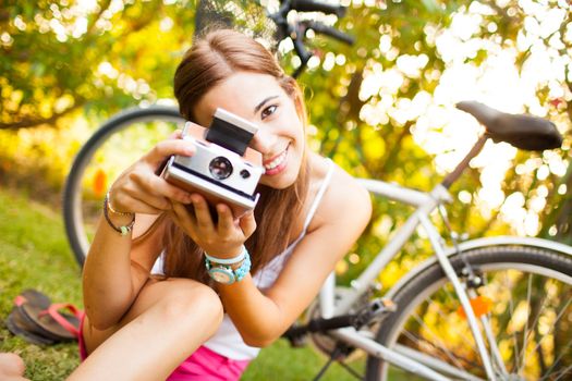 beautiful young woman playing with a vintage camera