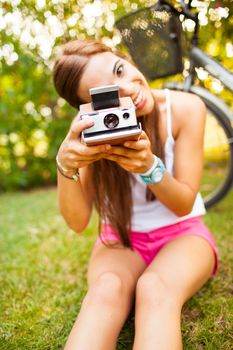 beautiful young woman playing with a vintage camera