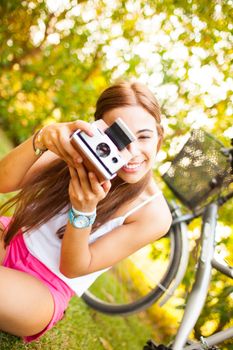 beautiful young woman playing with a vintage camera