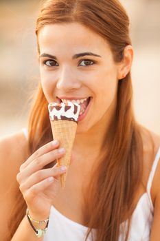 portrait of a young beautiful woman eating ice-cream cone