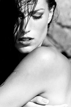 Portrait of sexy model enjoying a bath in the ocean with rocks