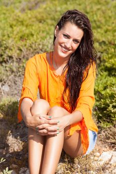 Portrait of young beautiful woman laughing wearing orange shirt