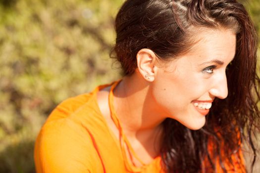 Portrait of young beautiful woman laughing wearing orange shirt