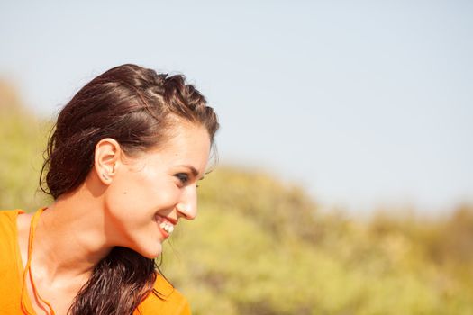 Portrait of young beautiful woman laughing wearing orange shirt