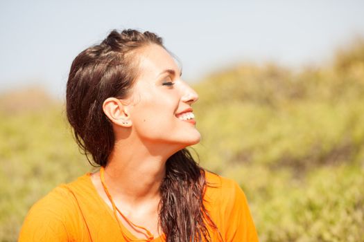 Portrait of young beautiful woman laughing wearing orange shirt