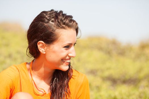 Portrait of young beautiful woman laughing wearing orange shirt