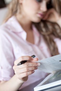 young beautiful woman reading a book at home