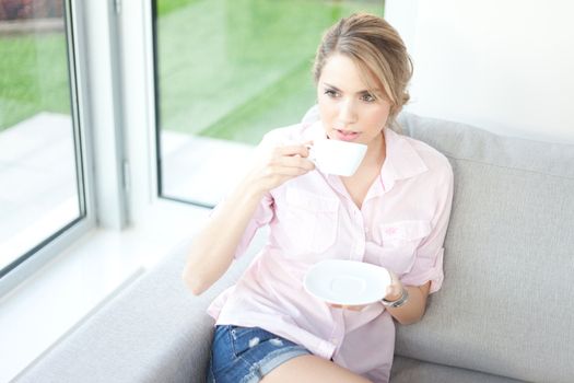 young beautiful woman drinking coffee or tea