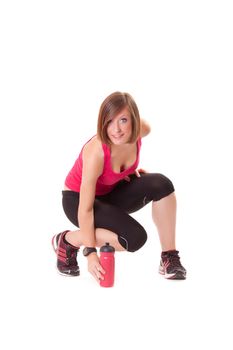 young beautiful sport woman takes a bottle and smile isolated on white background