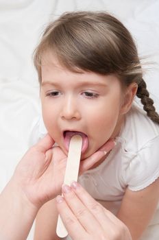 Doctor check throat of little girl