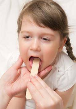 Doctor check throat of little girl