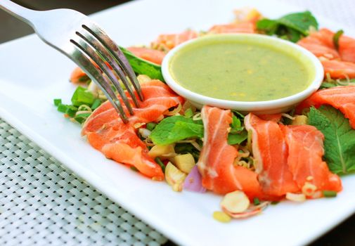 Spicy salmon salad and wasabi sauce with fork