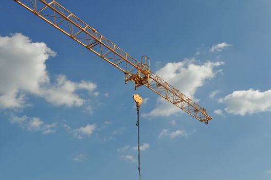 Building crane in a construction site over blue sky