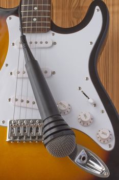 Electric guitar with microphone, over a wooden background