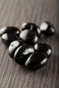 Little black stones over a wooden background