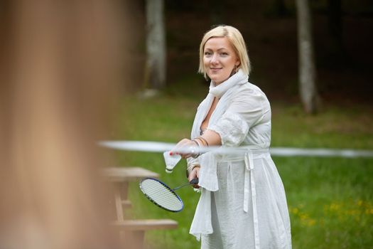 Portrait of a beautiful mature woman with racquet and shuttlecock ready to serve