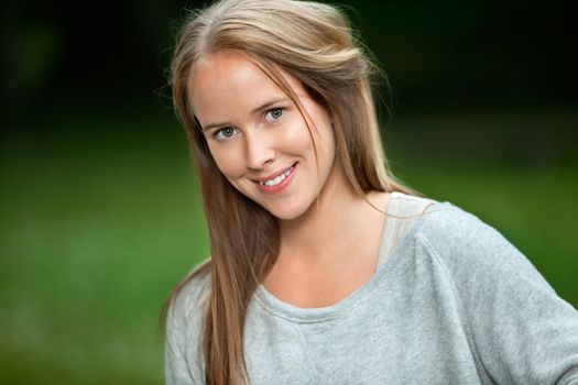 Portrait of a cute young woman with long hair smiling