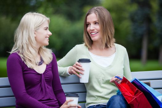 Shopping Women with Takeaway Coffee on bench.