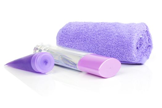 cosmetic bottles, with rolled towel, isolated on white