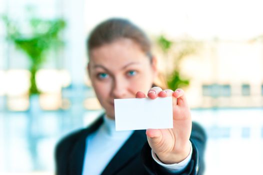 A smiling girl in costume shows a blank business card