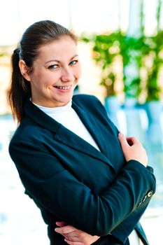 Portrait of successful business woman smiling on the background of a blurred office interior