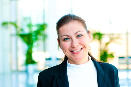 Portrait of a smiling girl on the background of the manager de-focus office interior