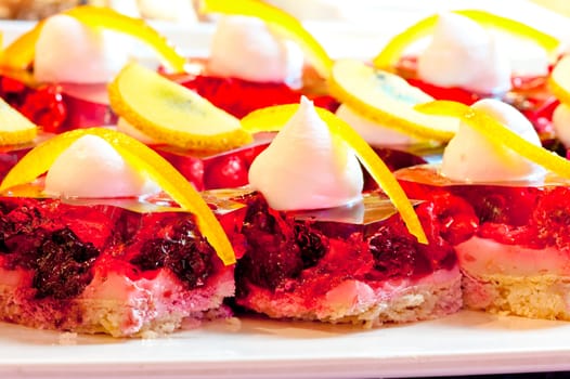 Biscuit dessert with fruit and berry jelly, whipped cream and orange zest