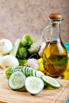 cucumber onion and garlic with an olive oil bottle on a kitchen table