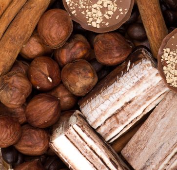 Sweets, cinnamon, nuts and coffee beans on a saucer, on burlap background.