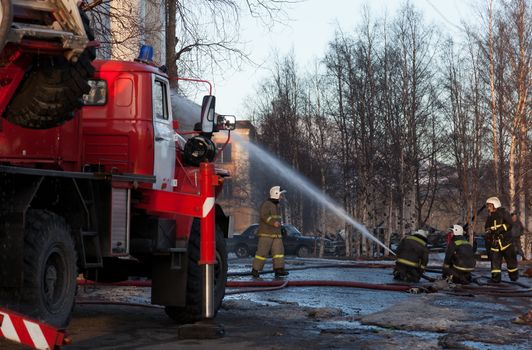 Firefighters extinguish a fire hose from the tap. only editorial