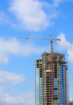 Modern building under construction against blue sky