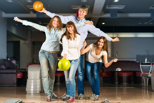 Group of young friends playing bowling, spending time with friends