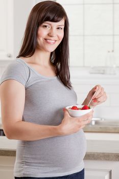 Portrait of a healthy pregnant woman with meal of granola and fruit