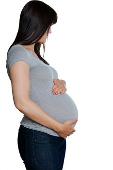Pregnant woman with hands on stomach standing against white background