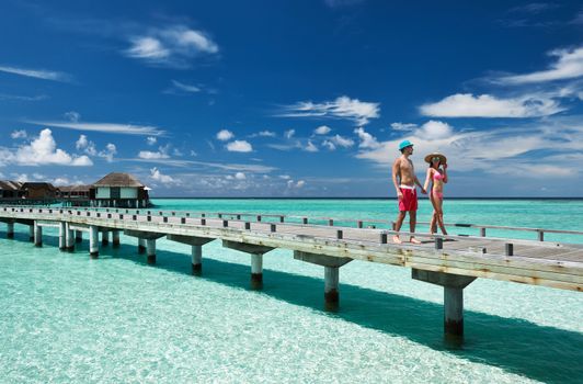 Couple on a tropical beach jetty at Maldives